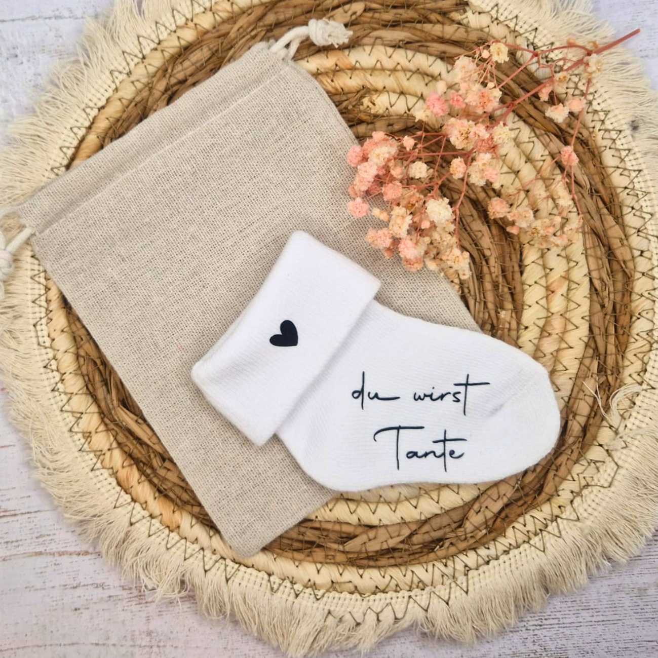 Babysocke zur Schwangerschaftsankündigung mit Aufdruck „du wirst Tante“ und Baumwollsäckchen als Verpackung